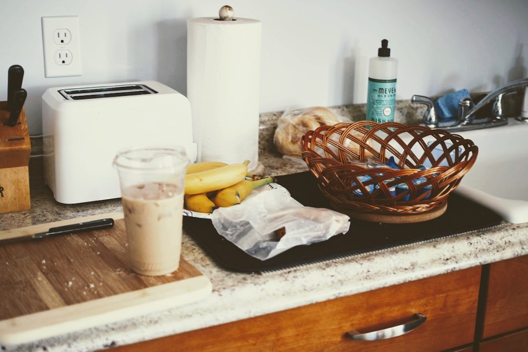 A cold coffee beside a compact breakfast setup on a working kitchen counter.