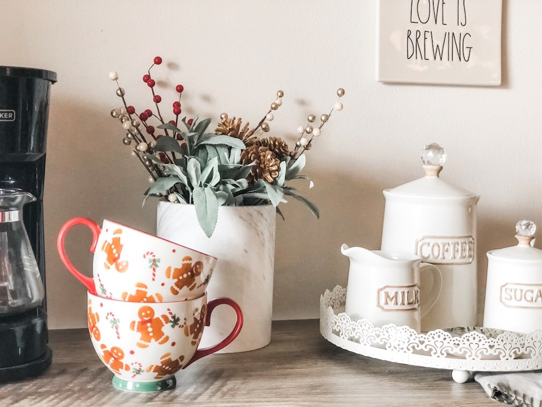 Coffee canisters and mugs grouped together below a compact kitchen shelf.