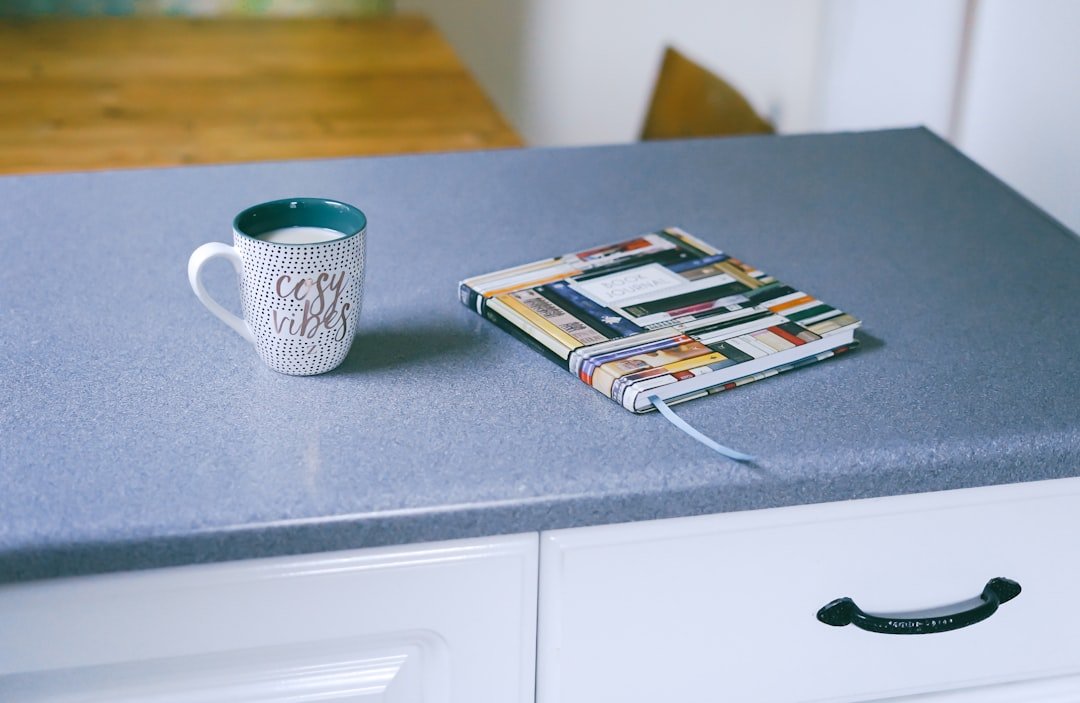 A coffee mug and notebook on a quiet kitchen counter for planning small daily upgrades.