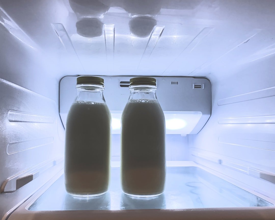 Two bottled cold drinks stored upright inside a refrigerator.