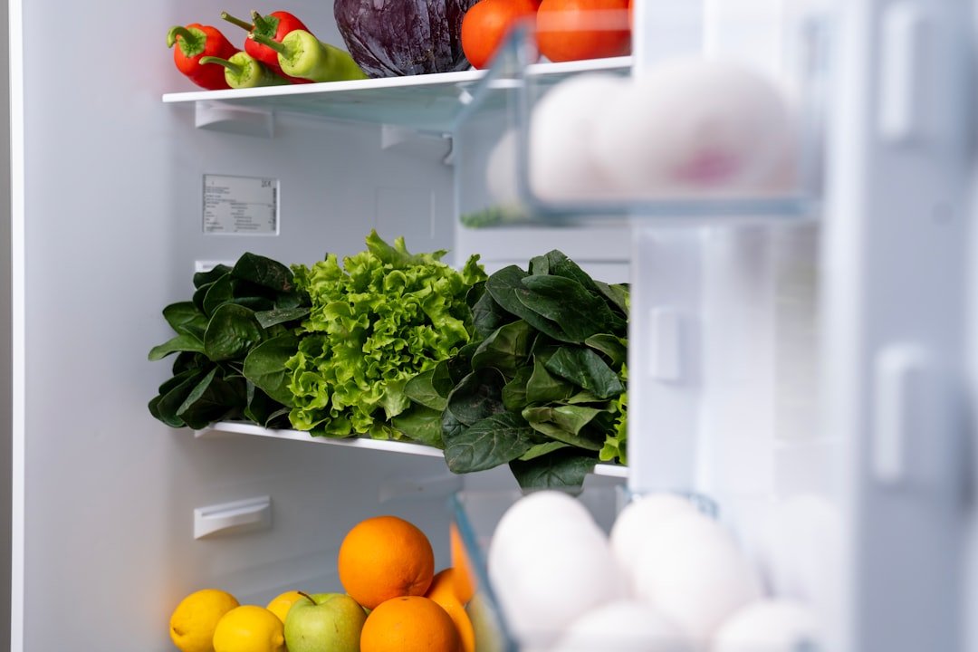Open refrigerator with fresh produce and containers for drink bottle planning.