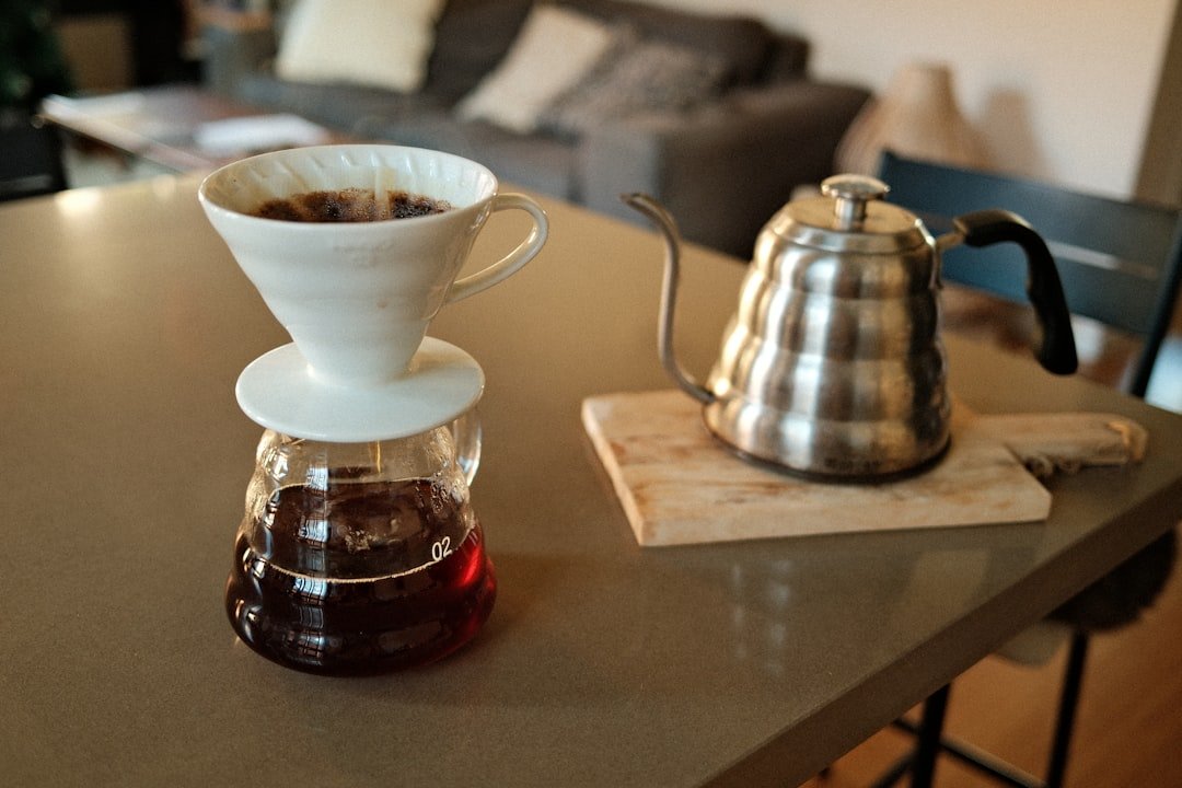 Pour-over brewer and gooseneck kettle set up on a home counter.