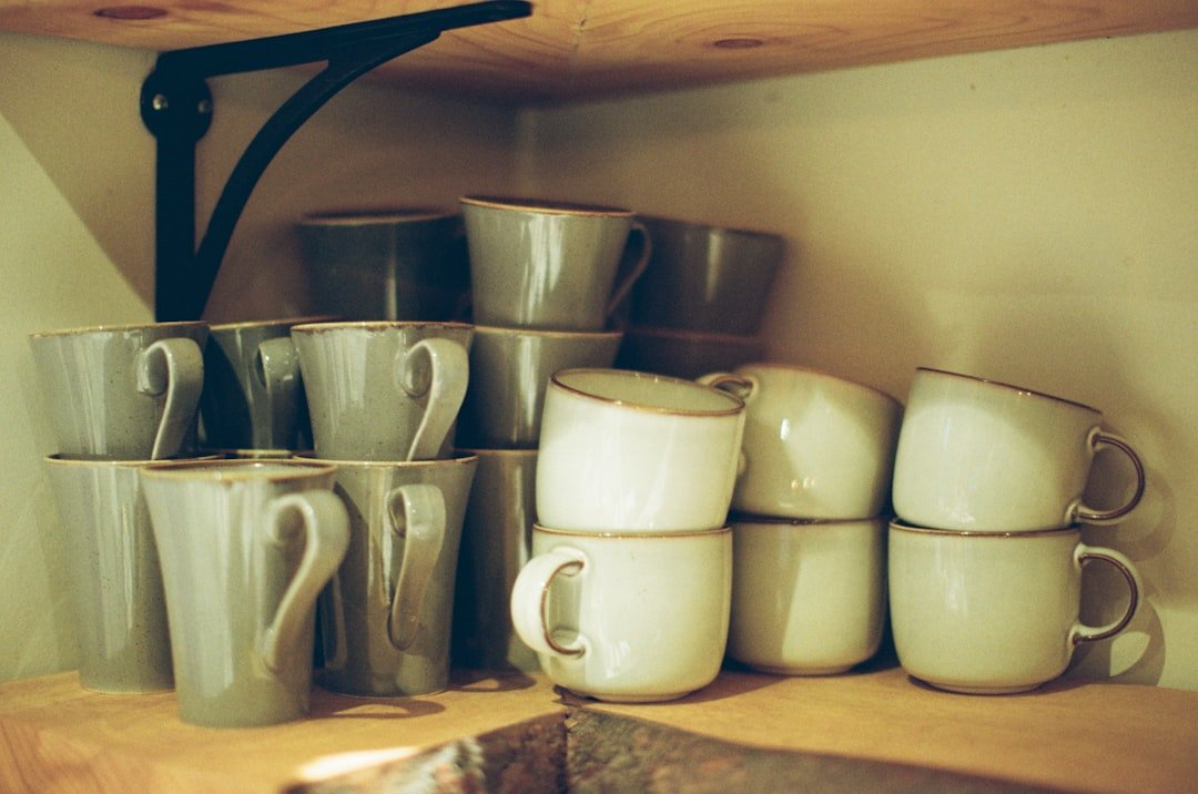 Stacked mugs and pitchers arranged on a compact open shelf.