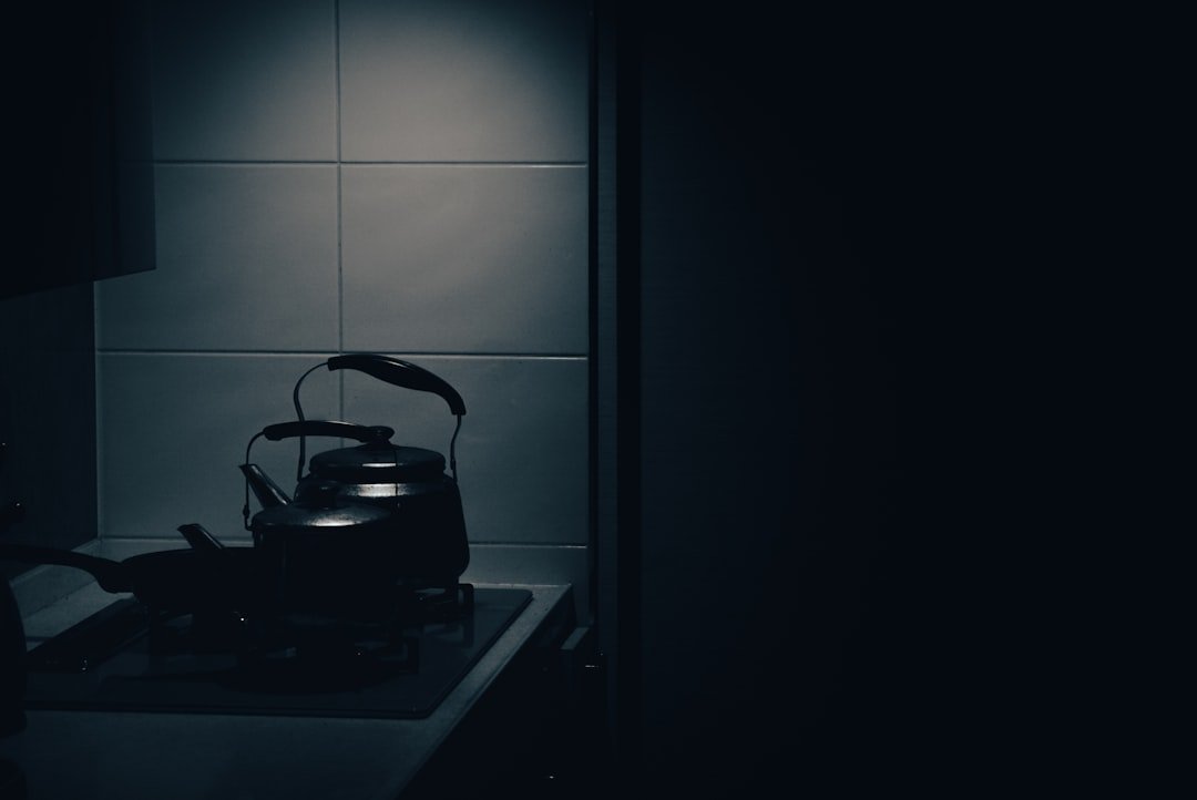 Tea kettle warming on a stovetop for an evening drink station.